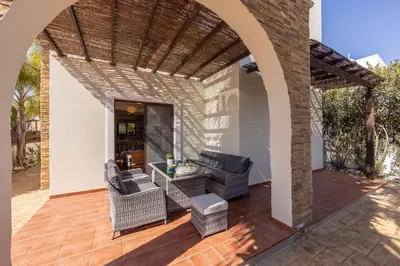 an outdoor patio with a table and chairs and a brick wall at Villa Ionion 27 in Ayia Napa
