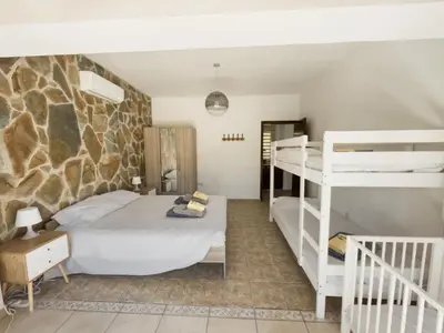 a bedroom with two bunk beds and a stone wall at Leo's Paradise in Protaras