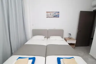 two twin beds in a small room with white walls at Diamond villas in Protaras