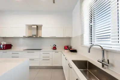 a white kitchen with white cabinets and a sink at Seafront Villa Maya by Ruidoso Luxury in Ayia Napa