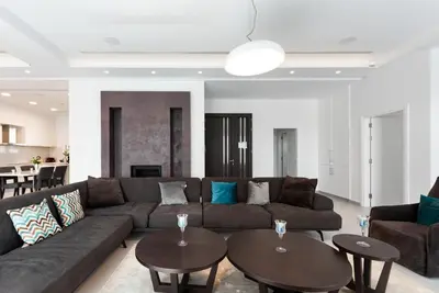 a living room with a couch and two tables at Seafront Villa Maya by Ruidoso Luxury in Ayia Napa