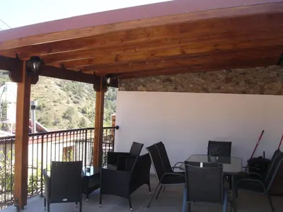 a patio with tables and chairs on a balcony at Love Holiday Suite 1 in Tris Elies