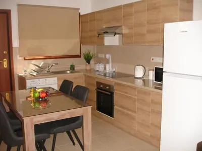 a kitchen with a table and a white refrigerator at Love Holiday Suite 2 in Tris Elies