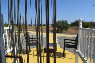 two chairs on a porch with a view of a yard at MERSINERA PARADISE GARDEN STARS HOUSE in Larnaka