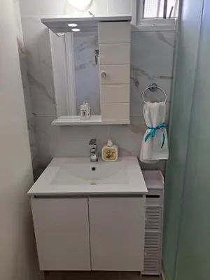 a bathroom with a white sink and a mirror at House Near The Beach (Militsa & Aggeliki) in Pervolia