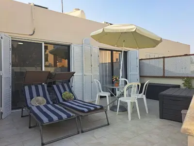 a patio with a table and chairs and an umbrella at House Near The Beach (Militsa & Aggeliki) in Pervolia