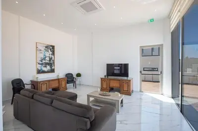 a living room with two couches and a tv at MAXOR PALACE in Protaras