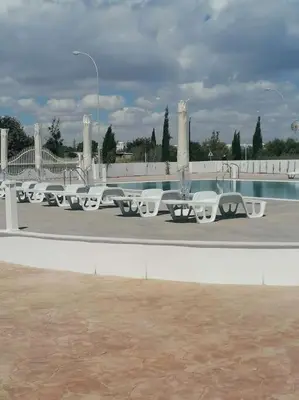a row of white tables and benches in a parking lot at MAXOR PALACE in Protaras