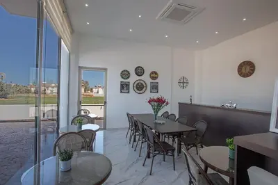 a restaurant with tables and chairs and a large window at MAXOR PALACE in Protaras
