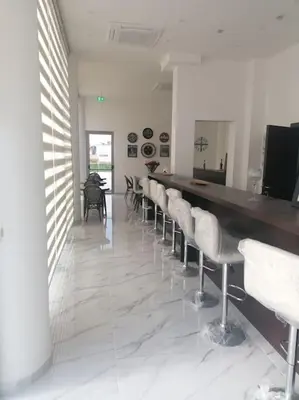 a bar with a row of white stools in a room at MAXOR PALACE in Protaras