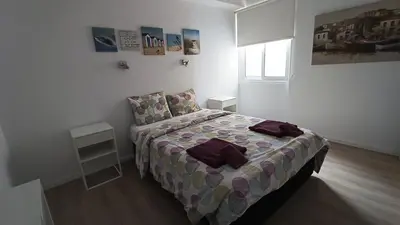 a bedroom with a bed in a white room at Sunorama Waterfront Apartment in Larnaka