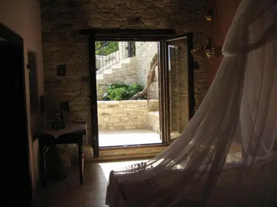 a bedroom with a window and a bed with a curtain at Our House in Vavla