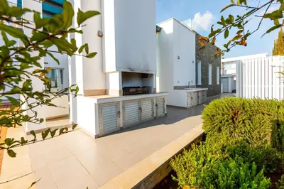 a patio with a kitchen on the side of a building at Seafront Villa Cecelia by Ruidoso Luxury in Ayia Napa