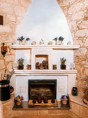 a living room with a fireplace with shelves at Magdalous House in Arsos