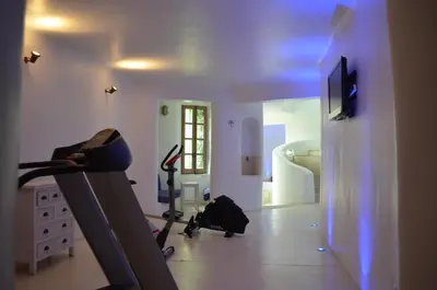 a room with a gym with a treadmill and a bedroom at Apokryfo Traditional Guesthouse in Lofou