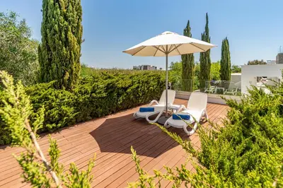 a patio with two chairs and an umbrella at Villa Marsali by Ruidoso Luxury in Ayia Napa