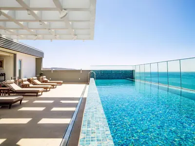 a swimming pool with a view of the ocean at The Tower at St Raphael Resort in Limassol