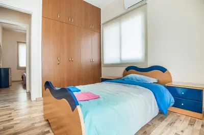 a bedroom with a large bed with a wooden headboard at Orion Apartment 401 in Larnaka