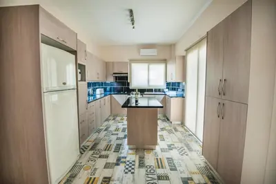 a large kitchen with blue tiles on the floor at Orion Apartment 401 in Larnaka