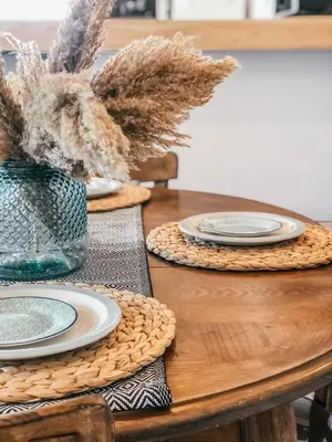a wooden table with plates and a vase of dry plants at Milea Mansion in Limassol