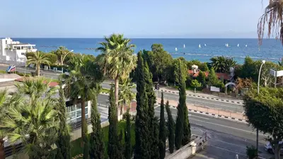 a view of a street with palm trees and the ocean at Seafront - 2 bedroom Modern in Limassol