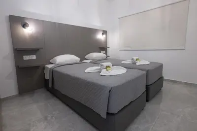 two beds with towels on them in a room at Bellagio Napa Suites in Ayia Napa
