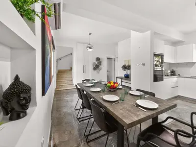 a kitchen and dining room with a wooden table and chairs at Elite Luxury Villa in Paralimni