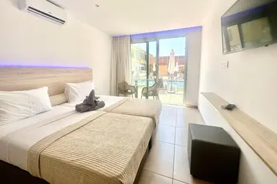 a hotel room with a bed with a stuffed animal on it at Sun Plaza Suites - Adults Only in Ayia Napa