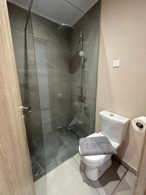 a bathroom with a shower with a toilet and a glass shower at Sun Plaza Suites - Adults Only in Ayia Napa