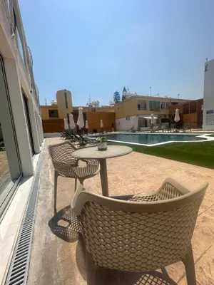 a patio with a table and chairs and a pool at Sun Plaza Suites - Adults Only in Ayia Napa