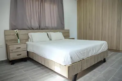 a bedroom with a large bed and a night stand at Ayia Napa Boutique Apartments in Ayia Napa