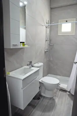 a white bathroom with a sink and a toilet at Ayia Napa Boutique Apartments in Ayia Napa