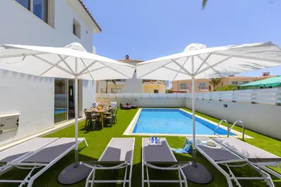 a patio with white umbrellas and a swimming pool at Protaras Palm Villa 54 in Protaras