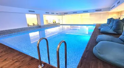 a large swimming pool with blue water in a building at Radisson Beach Resort Larnaca in Larnaka