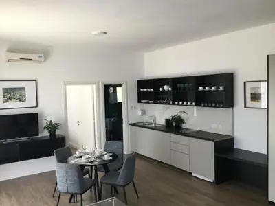 a kitchen and living room with a table and chairs at A.V Central Apartment in Larnaka