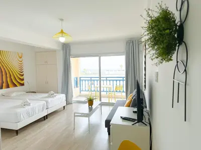 a bedroom with a bed and a couch and a tv at Lovely Studio Ayia Napa in Ayia Napa