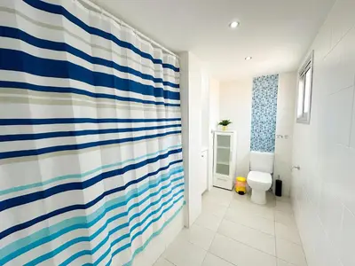 a bathroom with a blue and white striped shower curtain at Lovely Studio Ayia Napa in Ayia Napa
