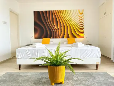 a bedroom with a white bed with a potted plant at Lovely Studio Ayia Napa in Ayia Napa