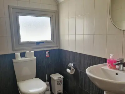 a bathroom with a toilet and a sink and a window at PERNERA 33 Beach House in Protaras