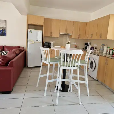 a kitchen with a table and chairs and a refrigerator at PERNERA 33 Beach House in Protaras