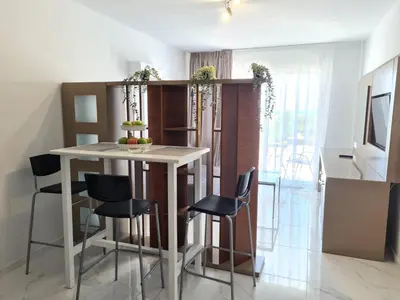 a kitchen with a white table and black chairs at Fotoxenia Luxury Apts in Paralimni