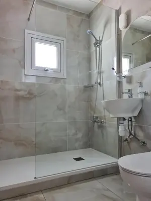 a bathroom with a shower and a toilet and a sink at Fotoxenia Luxury Apts in Paralimni