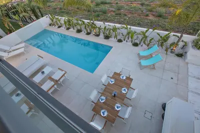 an overhead view of a swimming pool with chairs and a table at The White H Villa, Protaras, Fresh and Peaceful in Paralimni