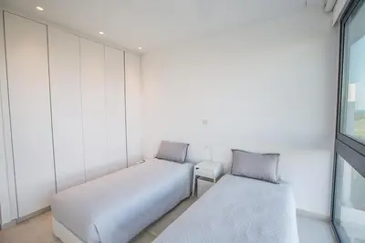 two beds in a room with a window at The White H Villa, Protaras, Fresh and Peaceful in Paralimni