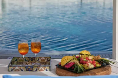 a table with two glasses of wine and a plate of food at Atlantica Sea Breeze, Adults Only in Protaras
