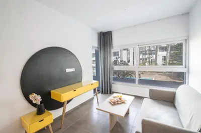 a living room with a yellow table and a couch at Anthea Hotel Apartments in Ayia Napa