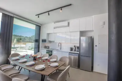 a kitchen with a table and chairs and a kitchen with a refrigerator at Elite Pearl Villas in Protaras