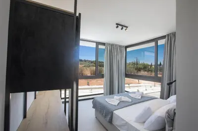 a bedroom with a bed and a large window at Elite Pearl Villas in Protaras