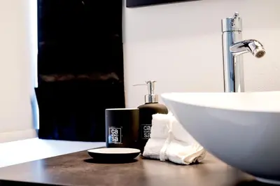 a bathroom counter with a sink and a bottle of soap at Casa BOHO in Alaminos