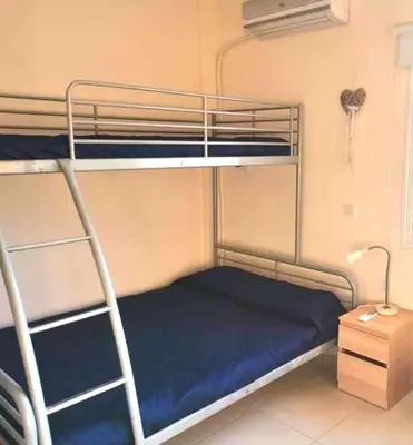a bedroom with two bunk beds with a blue mattress at Protaras Ionian Breeze House in Paralimni